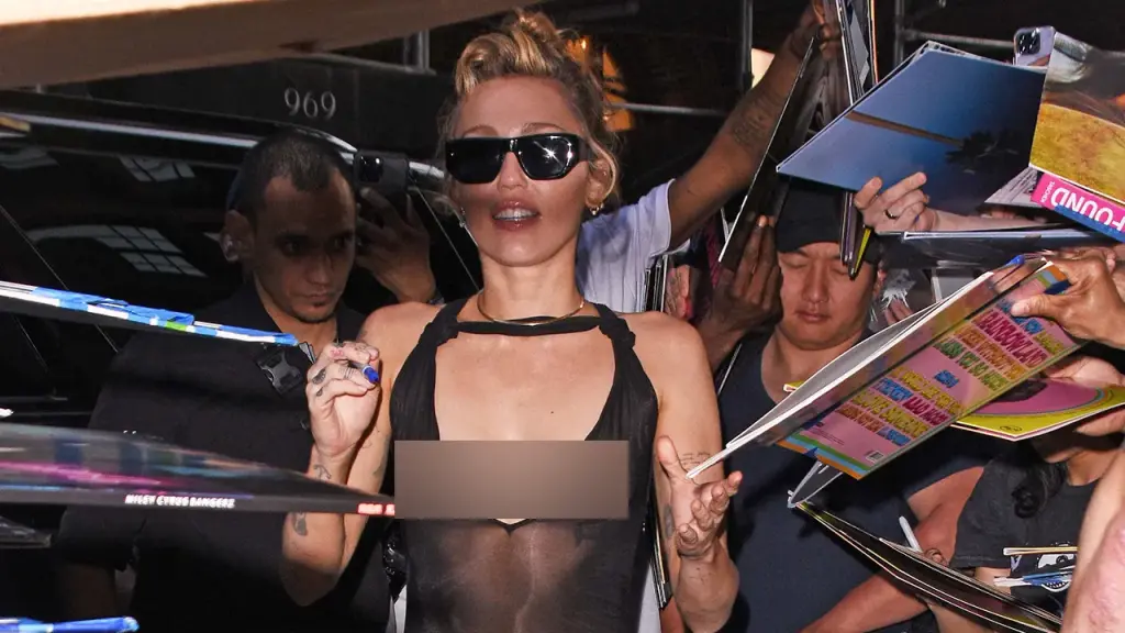 Miley Cyrus wears a see-through black dress without a bra while promoting her album