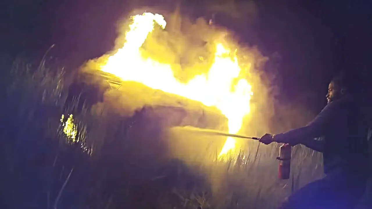 Motorists come to the aid of an elderly woman trapped in a burning car.