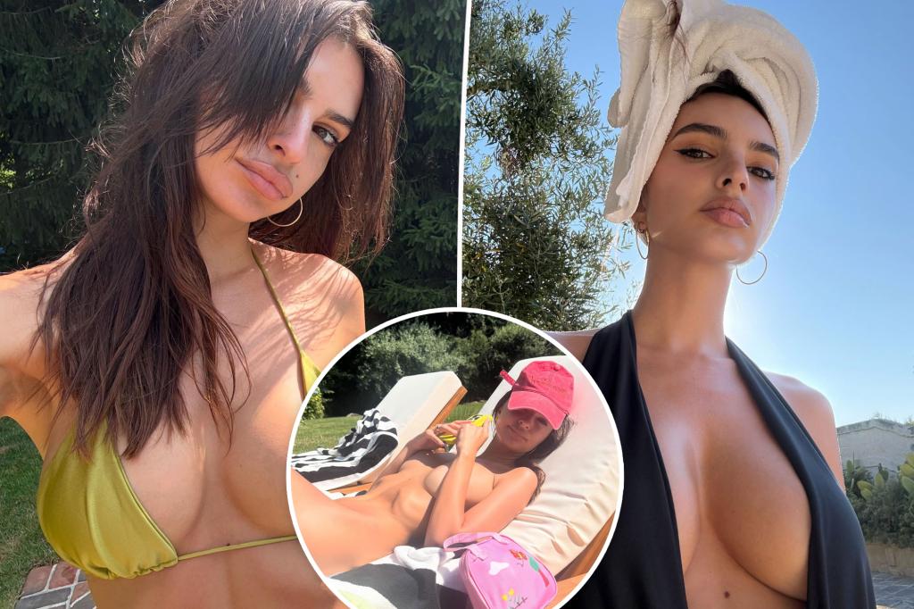 Emily Ratajkowski relaxes in the sun wearing only a baseball cap.