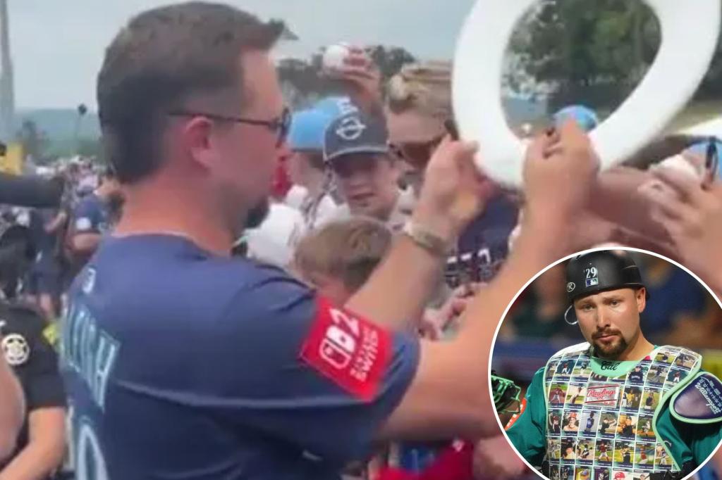 Cal Raleigh autographs a bathroom item for a fan at the Little League Classic