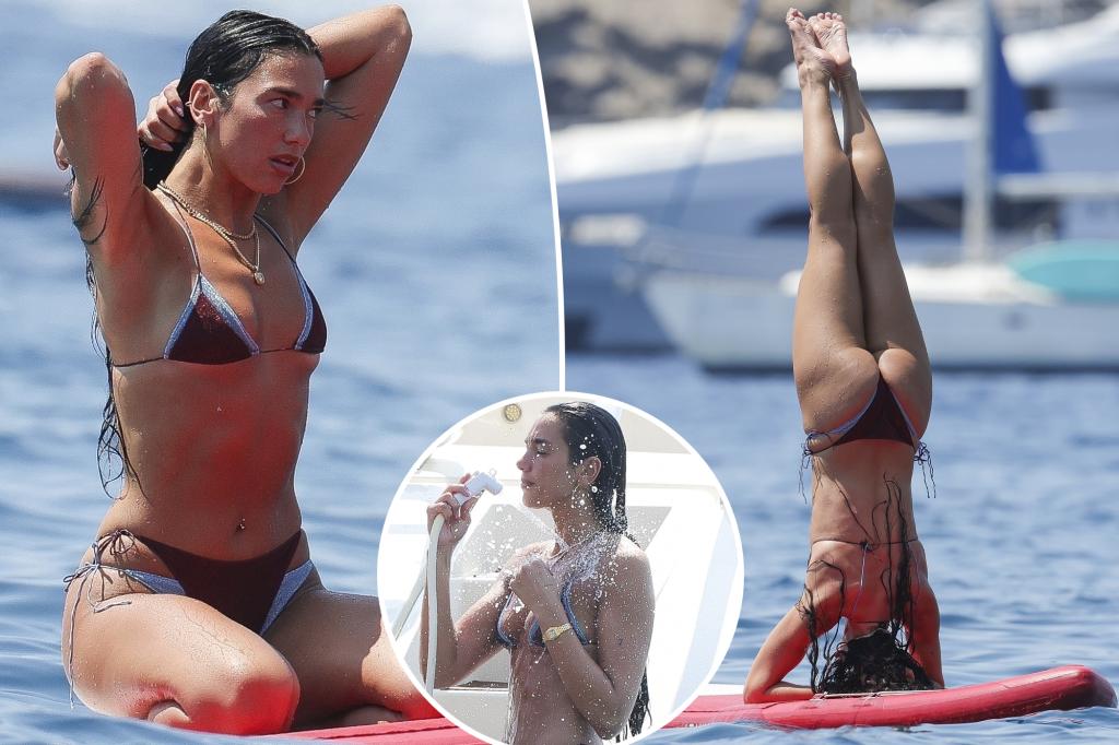Dua Lipa showcases her toned abs while doing paddleboard yoga in Ibiza.