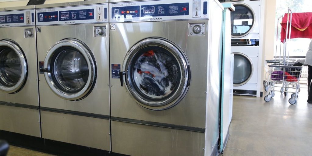 Footage captures bystanders restraining a man who was menacing a woman with a bat in a laundromat.