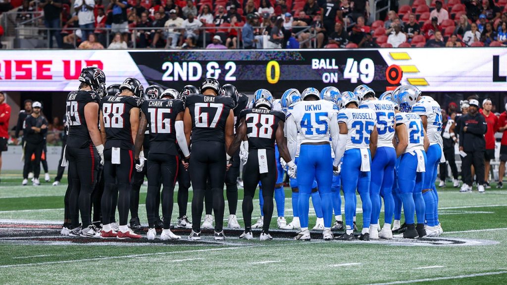 Lions and Falcons come together in prayer after Morice Norris is taken off the field in an ambulance.