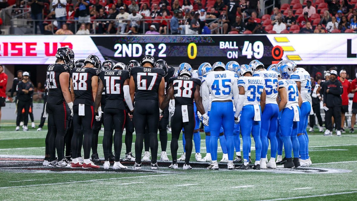 Lions and Falcons come together in prayer after Morice Norris is taken off the field in an ambulance.