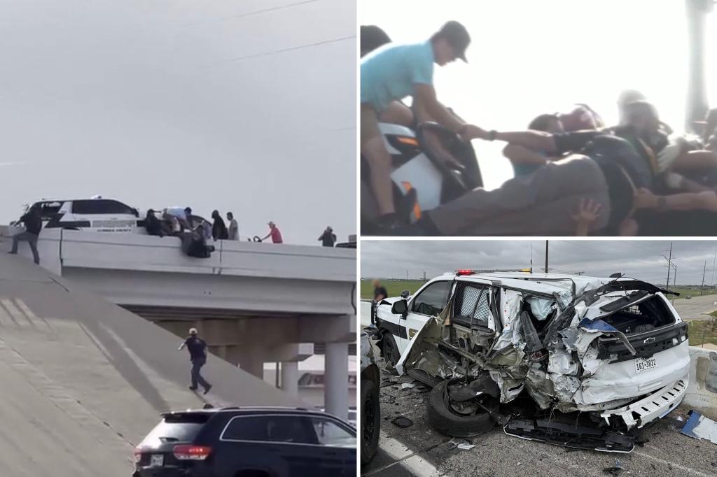 Video captures sheriff's deputy hanging from a bridge after his squad car is wrecked by a truck.