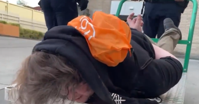 ICE Transports Handcuffed Portland Suspect on Flatbed Cart During Antifa Protests