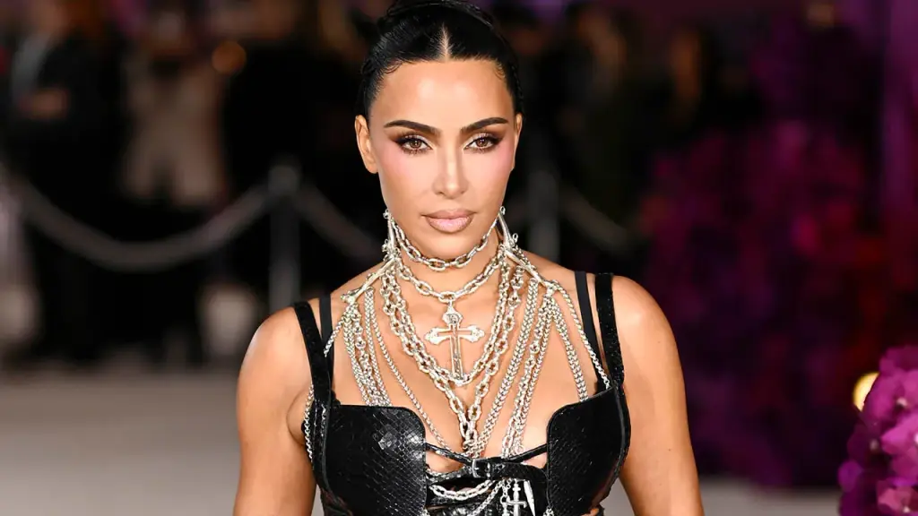 Kim Kardashian removes her face mask and flaunts a daring sheer dress in London.
