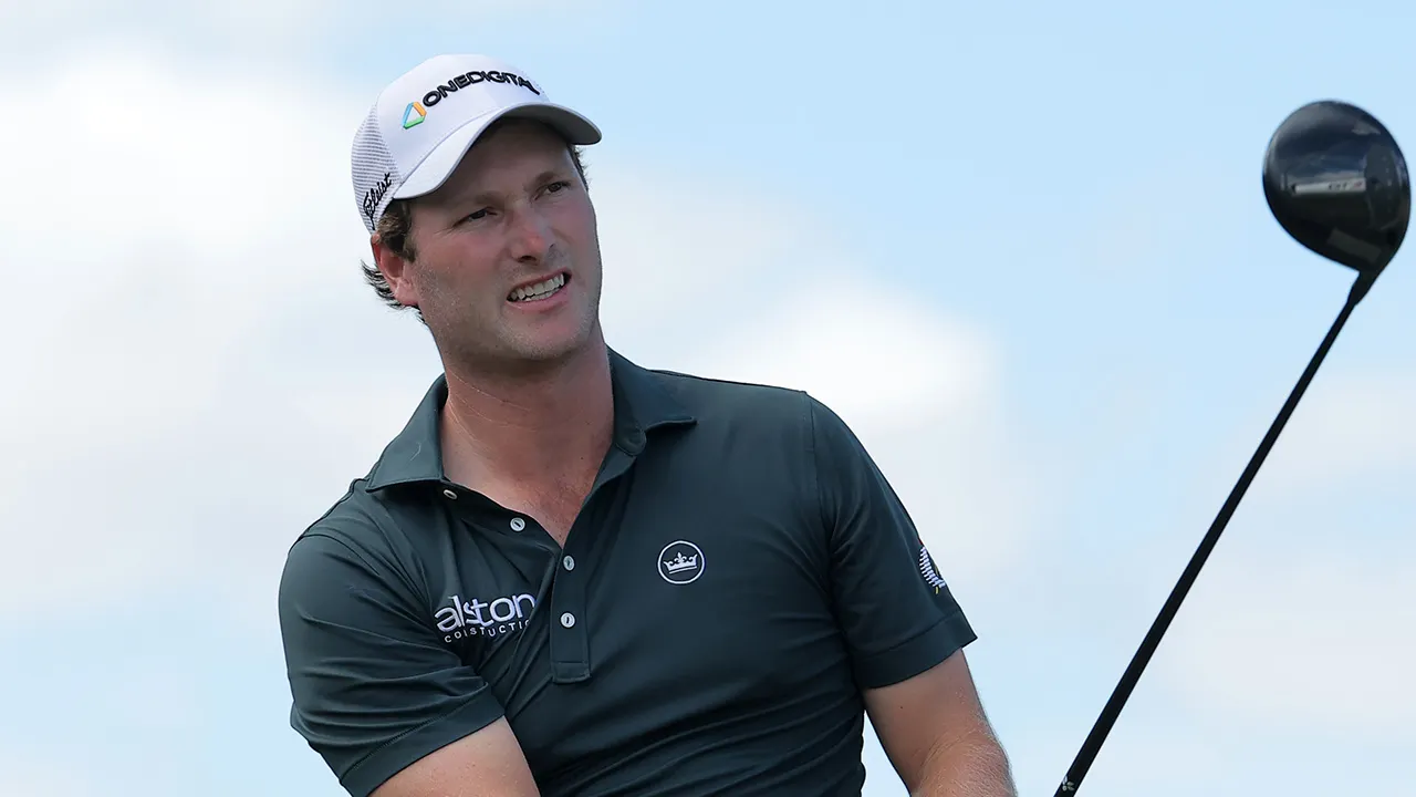 PGA Tour golfer Vince Whaley makes a shot near an alligator