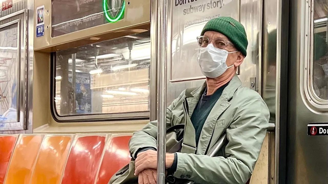 Tom Hanks seen riding the subway in New York City wearing a mask and beanie to blend in.