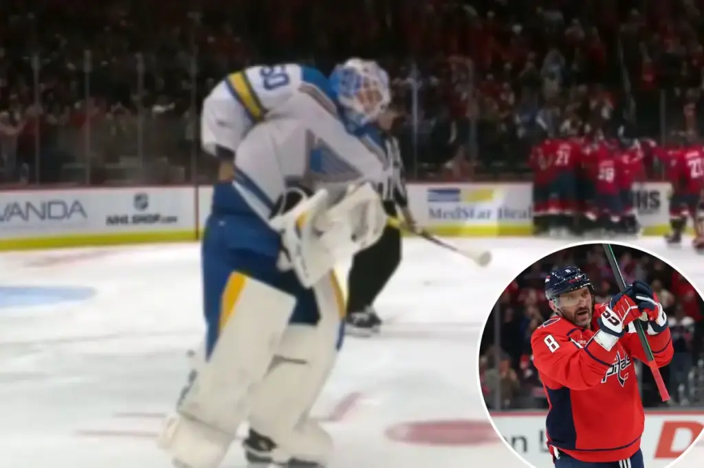Jordan Binnington of the Blues attempts to take Alex Ovechkin's puck for his 900th goal.