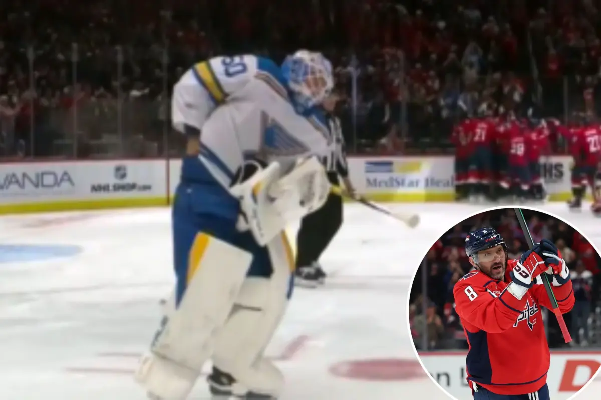 Jordan Binnington of the Blues attempts to take Alex Ovechkin's puck for his 900th goal.