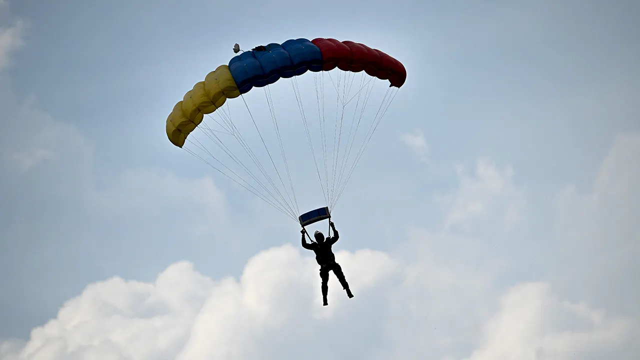 Skydiver's backup parachute accidentally opens, leaving him hanging from the aircraft
