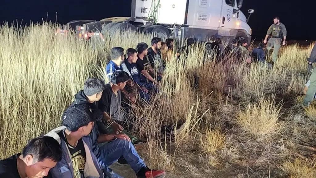 Texas man taken into custody after 23 migrants discovered concealed in truck during traffic stop.
