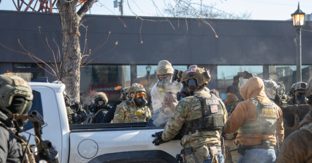 Citizens with weapons monitor the area in Minneapolis where Alex Pretti was shot