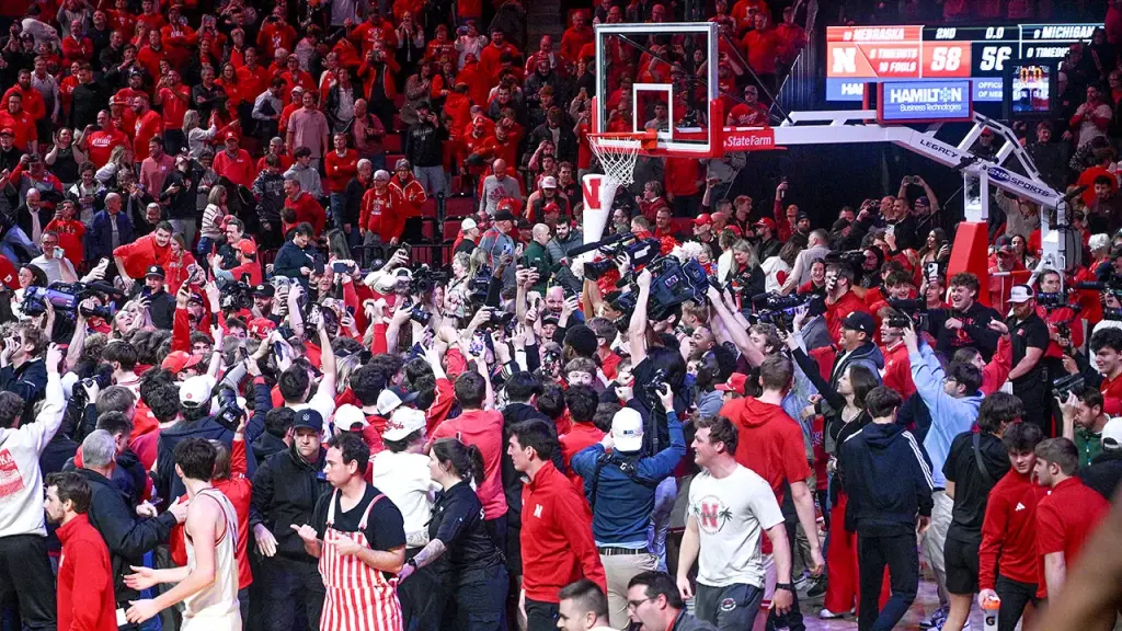 Nebraska players request fans to refrain from rushing the court following victory over Michigan State