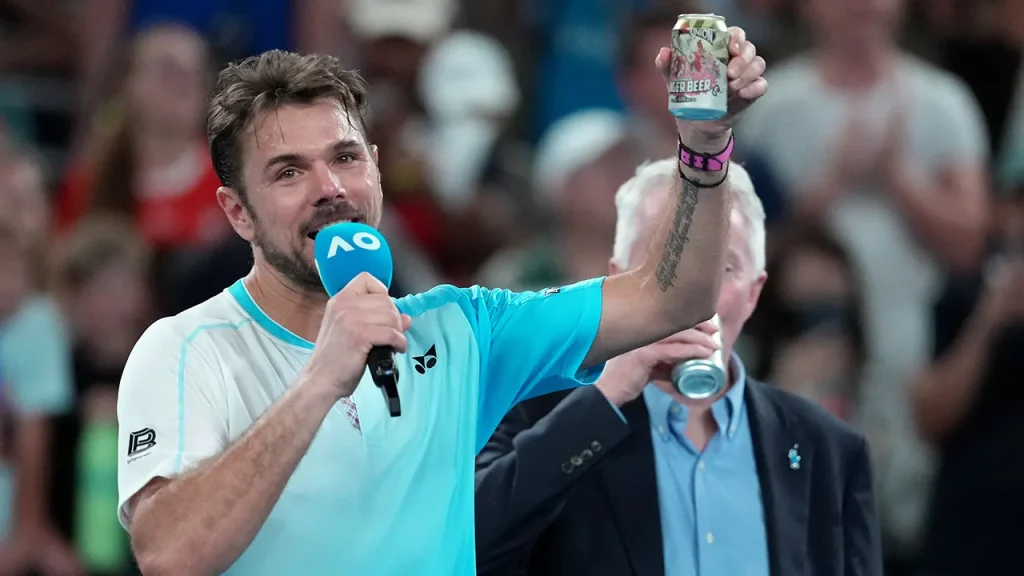 Stan Wawrinka has a beer on the court after his defeat to Taylor Fritz at the Australian Open