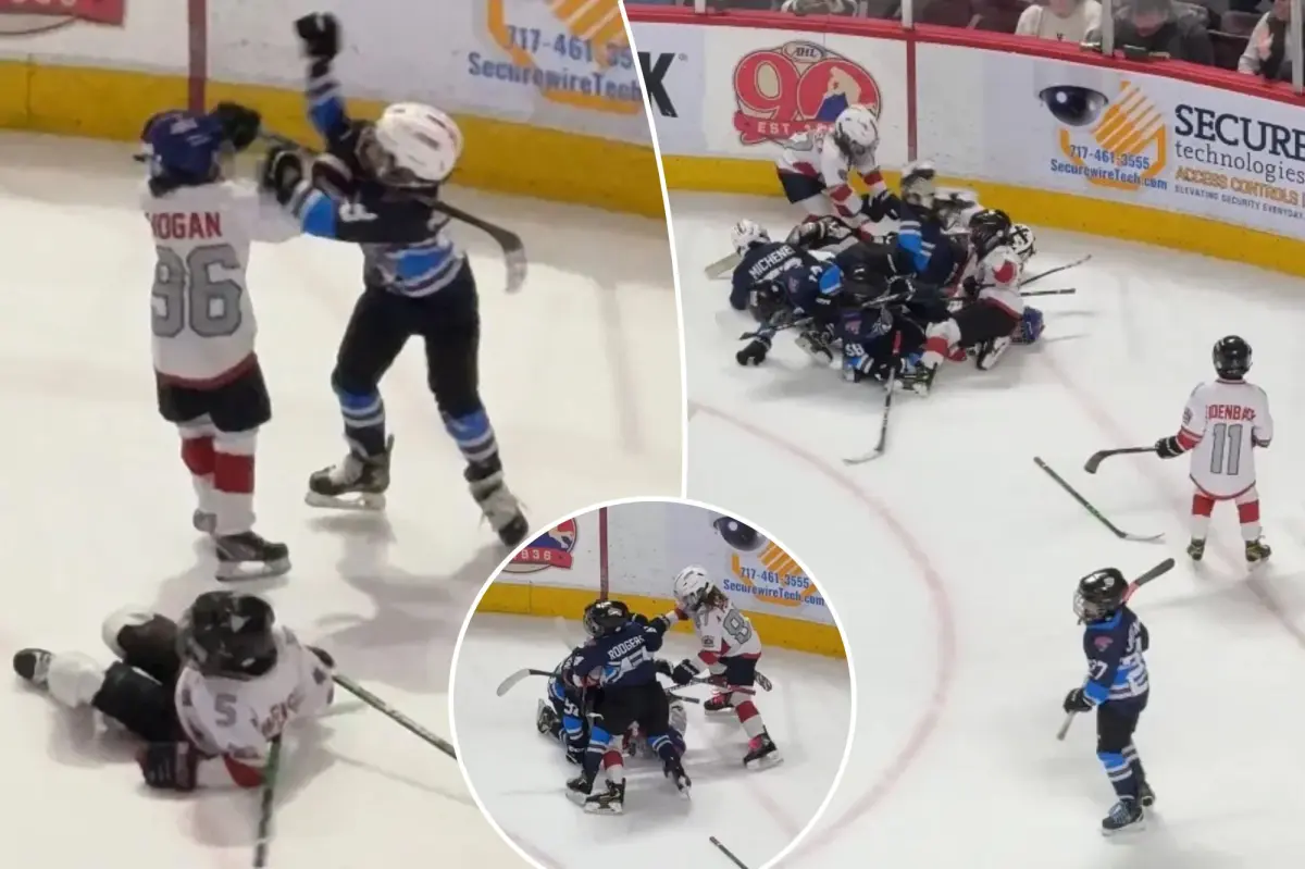 Young hockey players engage in a fierce fight during a game at an AHL arena.