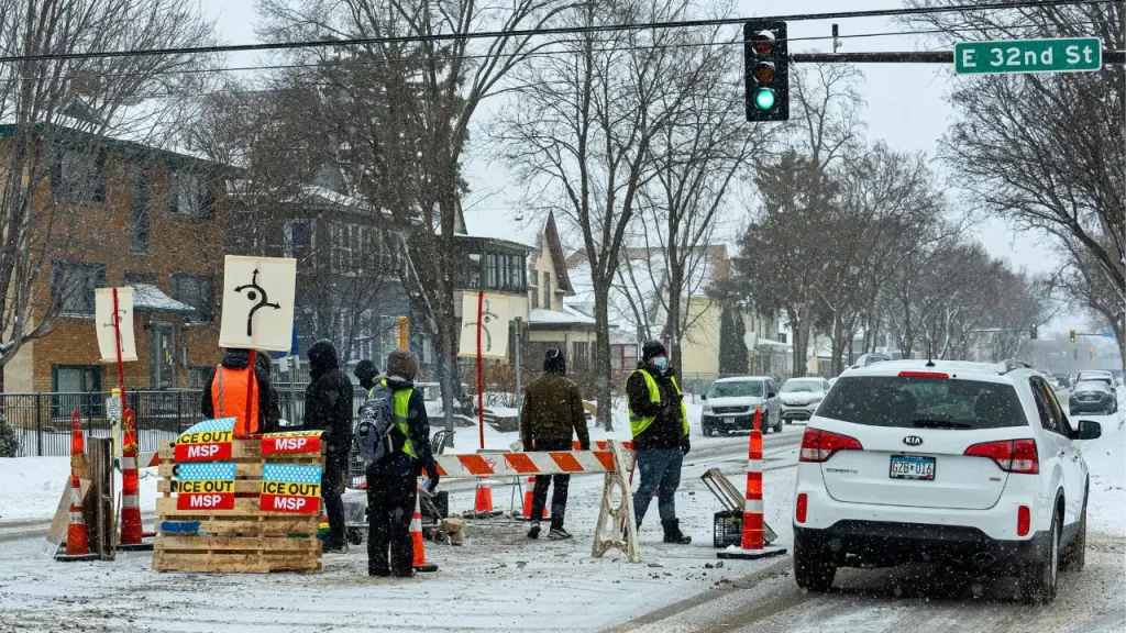 Protesters create a checkpoint on a Minneapolis street to halt cars.