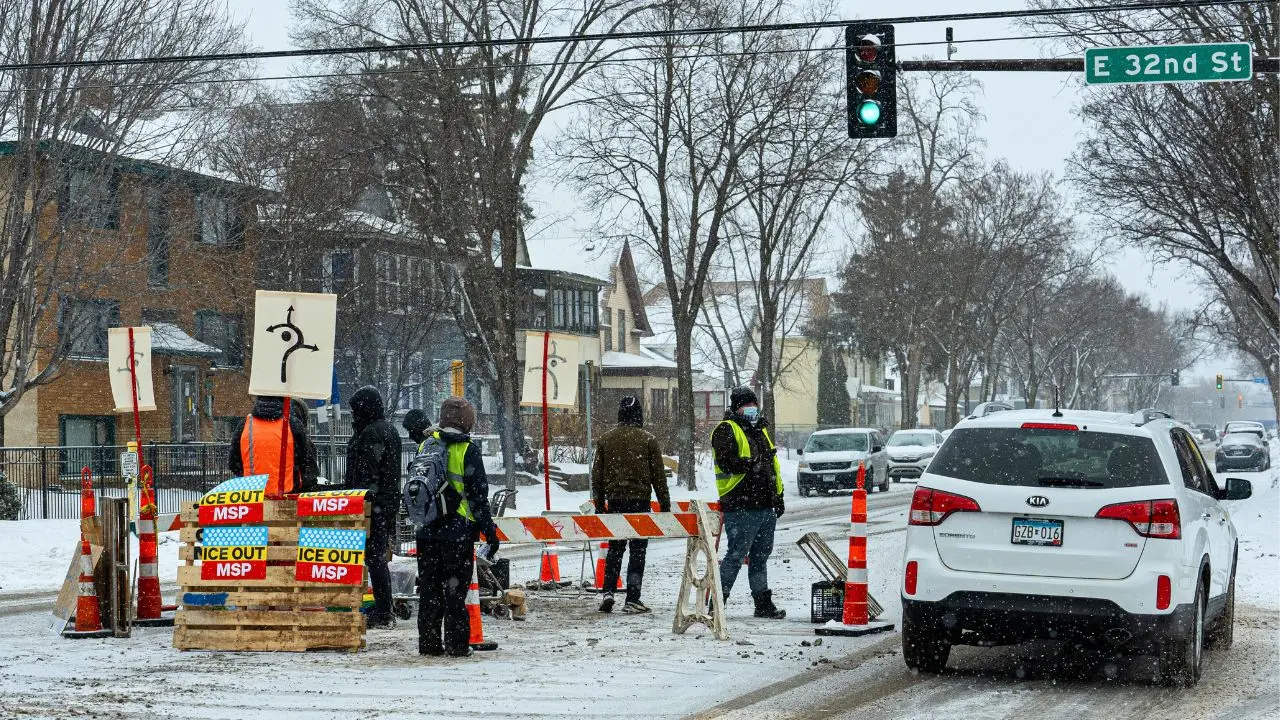 Protesters create a checkpoint on a Minneapolis street to halt cars.