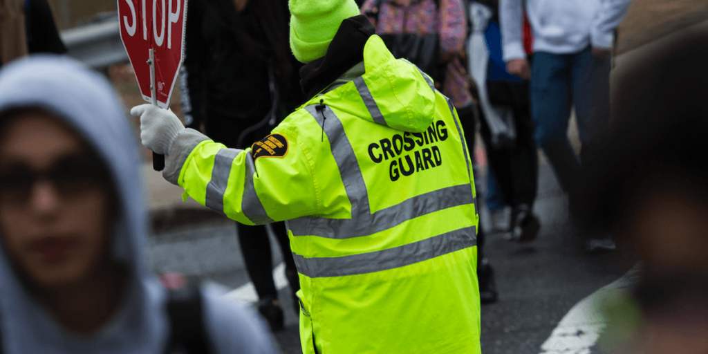 Man filmed hitting a female crossing guard, knocking her out while elementary school kids look on.