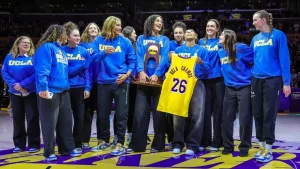 Jimmy Kimmel presents a fake trophy to the UCLA women's basketball champions to give to Trump