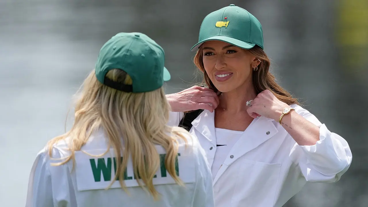 Paulina Gretzky serves as a caddy for Dustin Johnson during the Masters Par 3 Contest