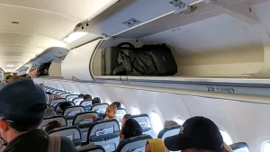 Travelers report that airlines are requiring baggage checks even with vacant overhead compartments.