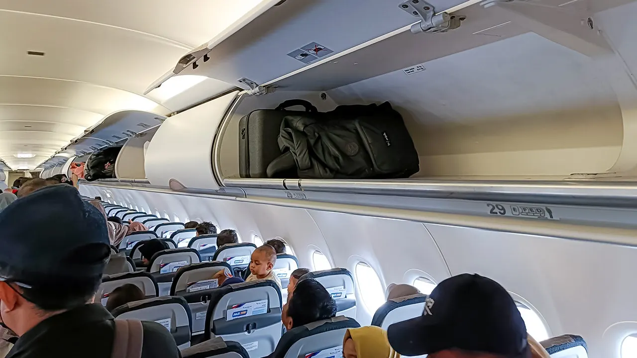 Travelers report that airlines are requiring baggage checks even with vacant overhead compartments.
