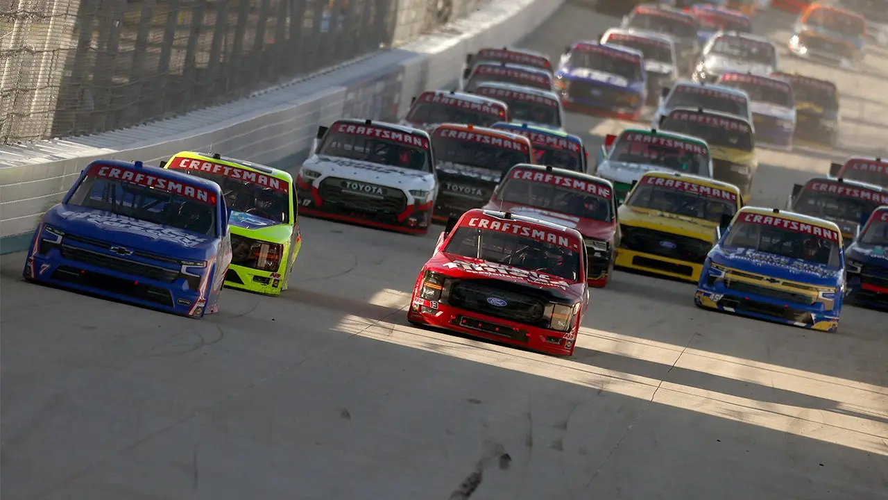 A NASCAR tire carrier protects a reporter from a runaway pit box ahead of the Craftsman Truck Series race.