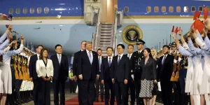 Trump visits China accompanied by a surprise guest and a group of business leaders.