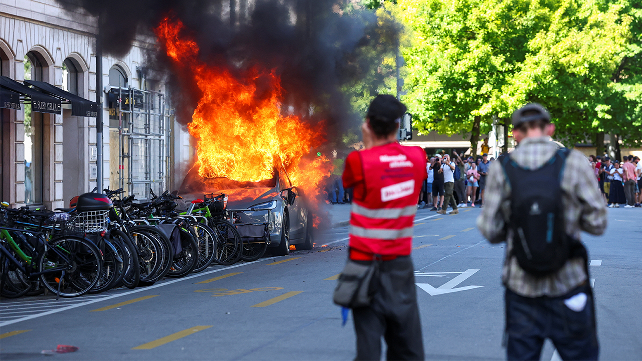 Protesters burn a Tesla and break windows at a UN office during an anti-G7 demonstration.