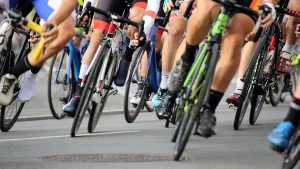 Senior fan on a mobility scooter causes cyclists to crash during a race by entering the course