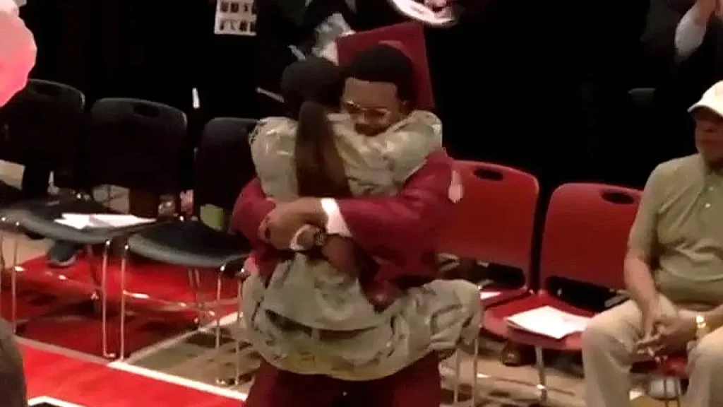Sister in the military surprises her brother by presenting him his diploma at graduation.