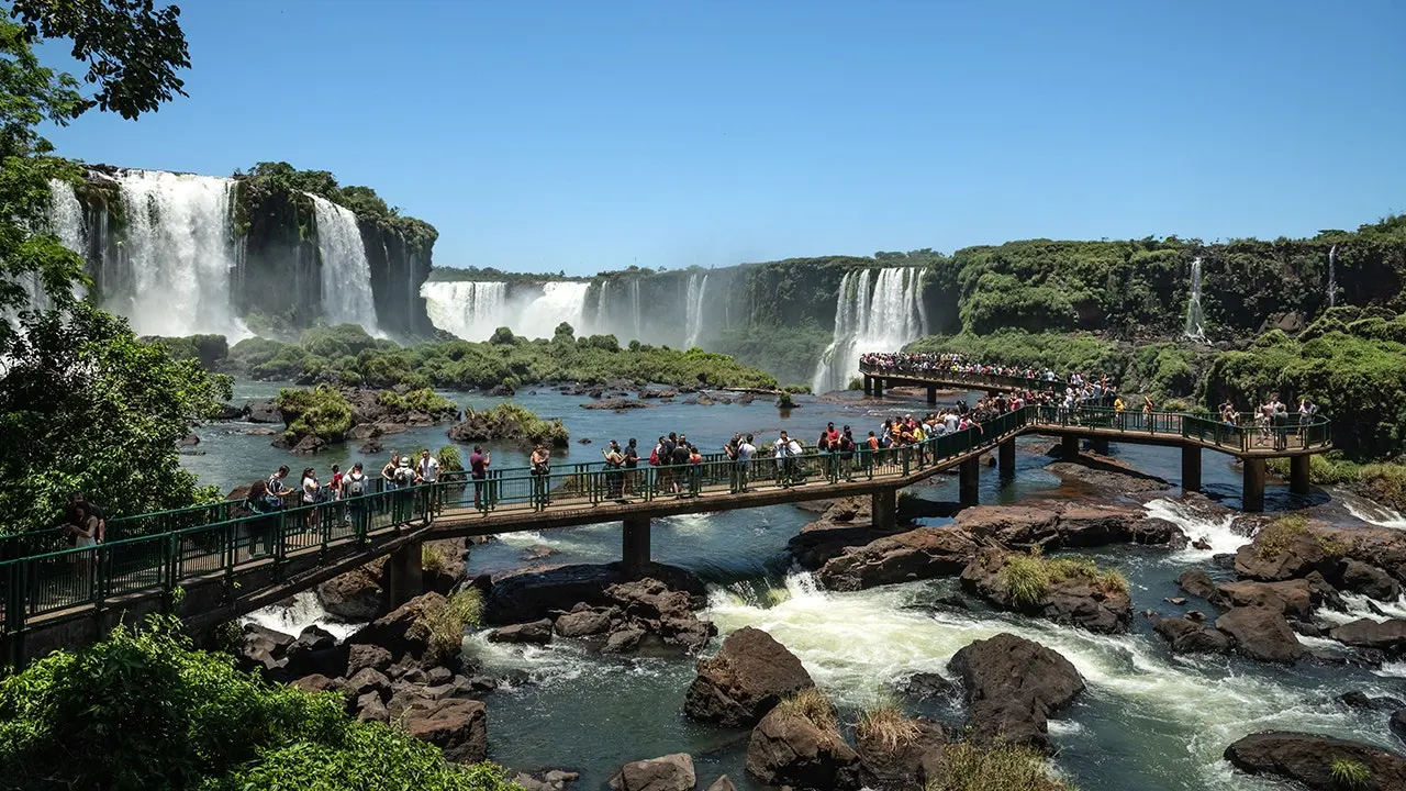 Tourist at Iguazu Falls summer visits climbs over barrier to get cellphone from river
