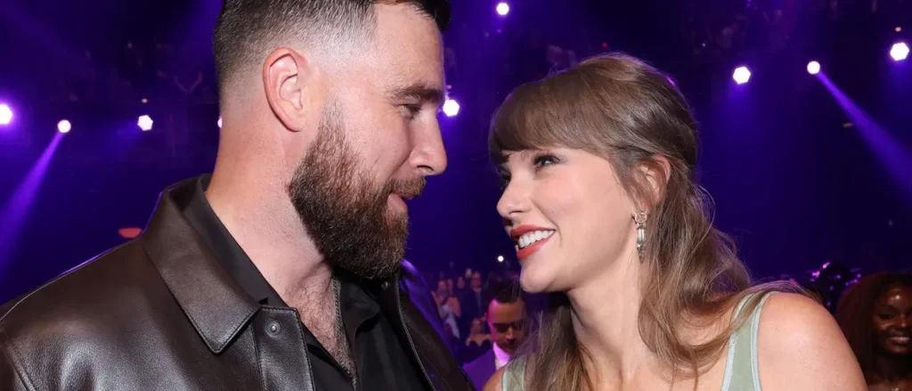 Adam Sandler advises Taylor Swift and Travis Kelce to &lsquo;Kiss Whenever You Can&rsquo; while officiating a wedding, coach mentions.