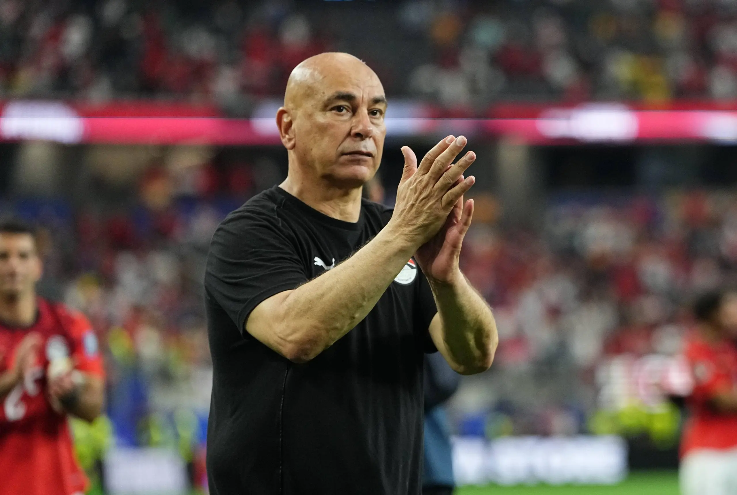 Egypt's national team coach holds up Palestinian flag following victory over Australia in the World Cup