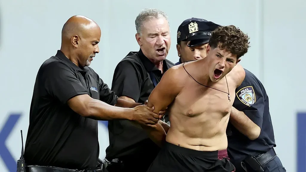 Three fans rush onto the field at Yankee Stadium, and security reacts strongly.