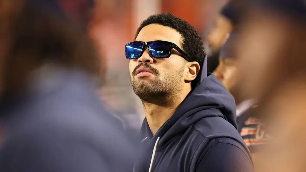 Caleb Williams, held back by a hamstring injury, observed casually walking along the Bears sideline during the national anthem.