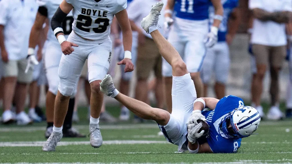 Massive high school football player tosses defender to the ground like a toy after making an interception.