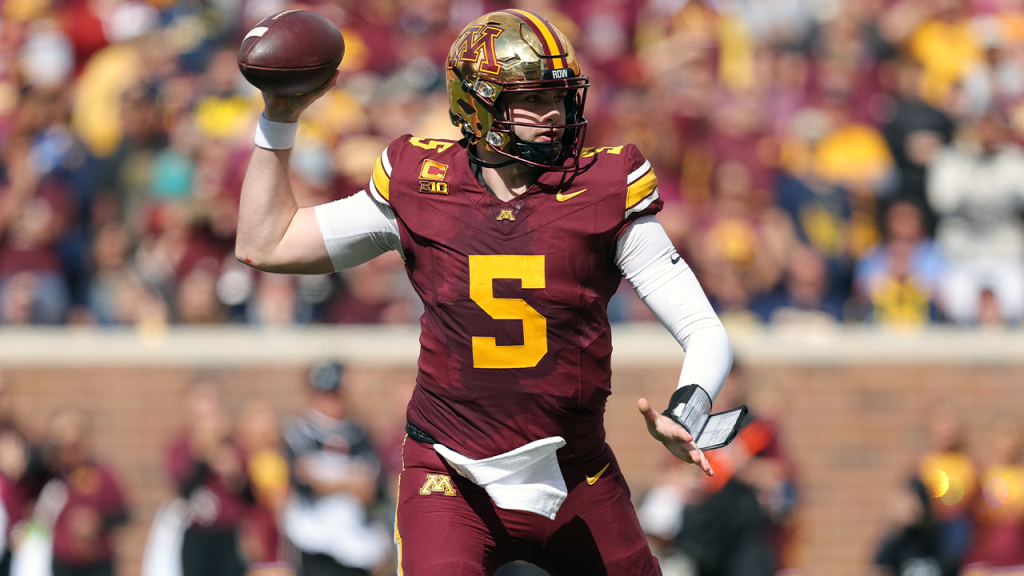 Minnesota quarterback receives a kick to the groin from a teammate during surprising victory against Michigan