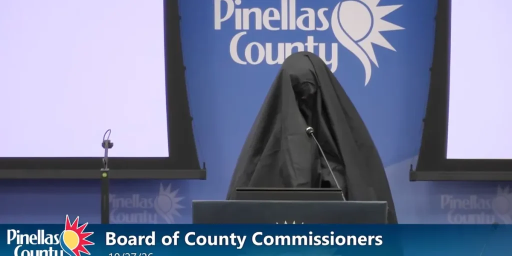 Woman in a Muslim burqa speaks at a public meeting in Florida, and her next action leads to her removal.